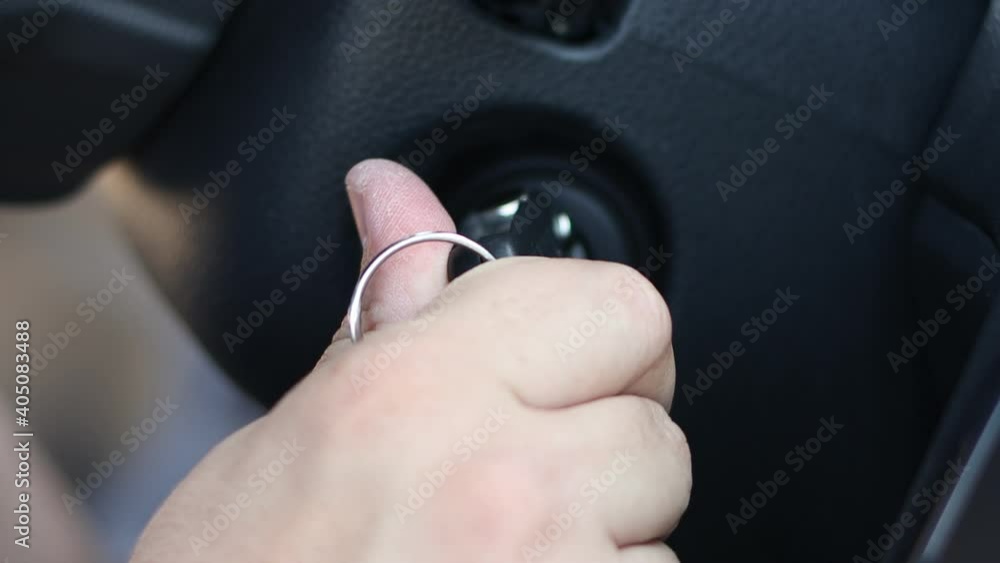 Man inserts the ignition key and starts the car. Man inserts the ignition key and starts the car.
