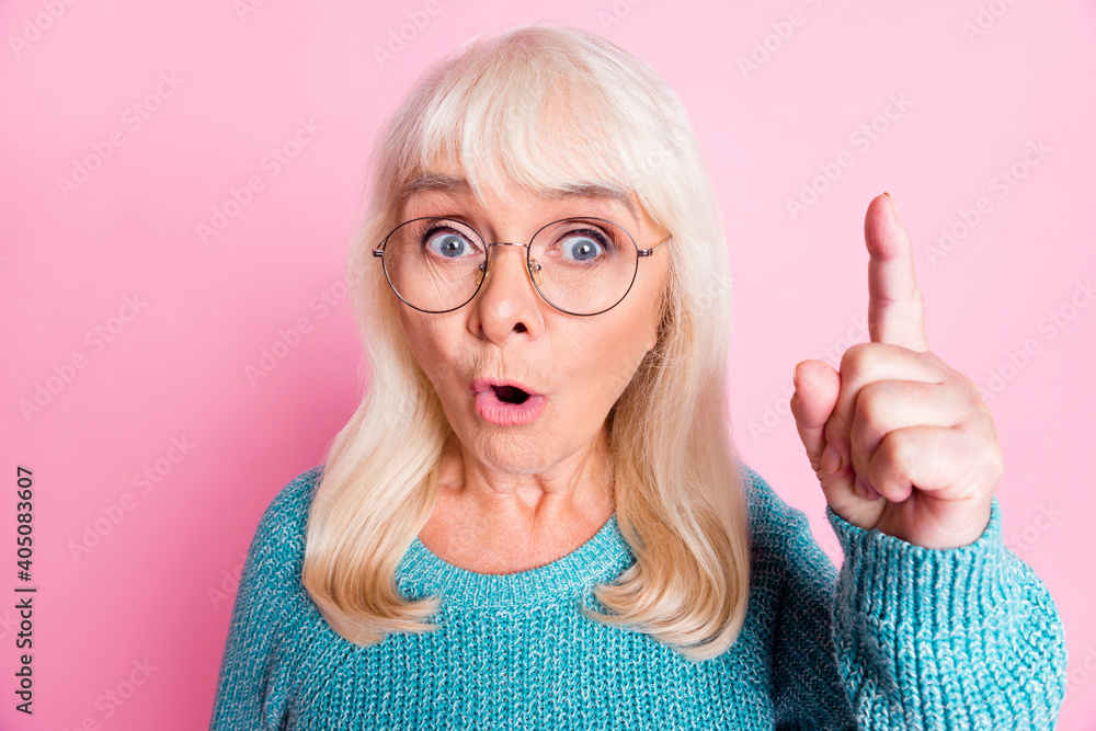 Photo of retired smart old lady direct finger up open mouth wear glasses blue sweater isolated pink color background Photo of retired smart old lady direct finger up open mouth wear glasses blue sweater isolated pink color background