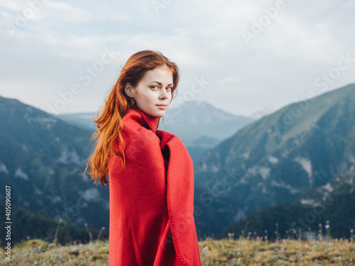 beautiful woman with warm blanket in the mountains and red hair model