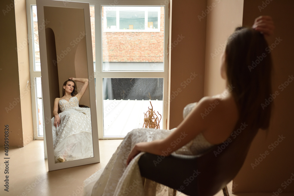 Young beautiful bride is sitting on a chair in the room. Young beautiful bride is sitting on a chair in the room.