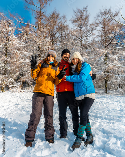 Three friends enjoying in the snowy forest in the month of January the Artikutza natural park in oiartzun near San Sebastián, Gipuzkoa, Basque Country. Spain