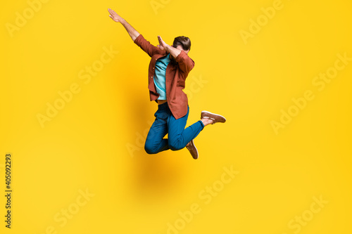 Full length body size photo of man showing hype dab sign dancing jumping isolated on bright yellow color background
