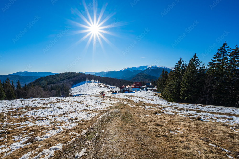 Sun star over winter mountain landscape in Romanian Carpathians