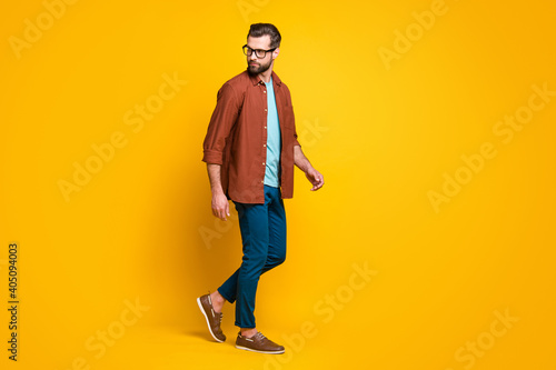 Full length body size photo of stylish man wearing casual clothes going isolated on vivid yellow color background copyspace