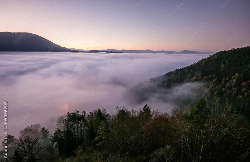 Sea fog in the pink light is very beautiful and fabulous, picturesque vague wave rolled on the slopes of the peaks