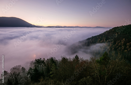 Sea fog in the pink light is very beautiful and fabulous, picturesque vague wave rolled on the slopes of the peaks