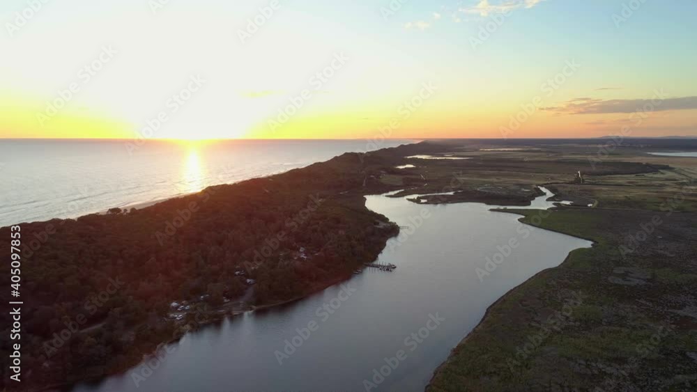 Aerial pan across ocean coastline and river at sunset in Australia Aerial pan across ocean coastline and river at sunset in Australia