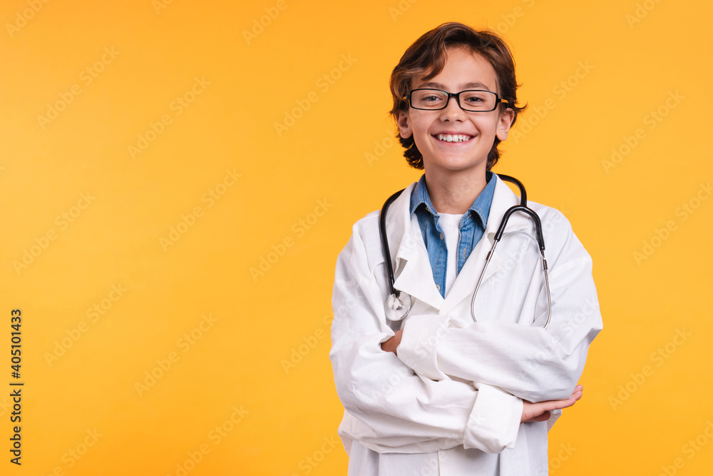 Smiling future male doctor in medical clothes with stethoscope isolated over yellow background Smiling future male doctor in medical clothes with stethoscope isolated over yellow background