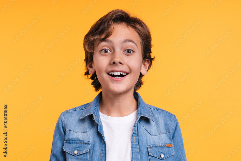 Close up portrait of 10s small surprised boy in casual clothes isolated over yellow background Close up portrait of 10s small surprised boy in casual clothes isolated over yellow background