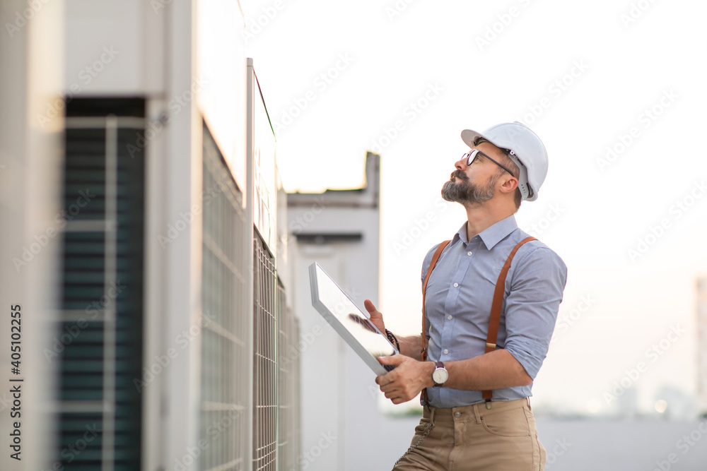 Portrait of Technician Electrical Engineer at rooftop building. Clean and green alternative energy concept. Portrait of Technician Electrical Engineer at rooftop building. Clean and green alternative energy concept.