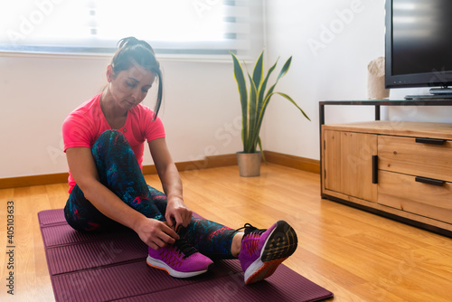  woman tying her shoes during a training at home