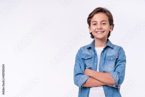Happy young caucasian boy in casual outfit with arms crossed isolated over white background photo