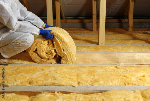Fotografie Worker insulate the attic with mineral wool
