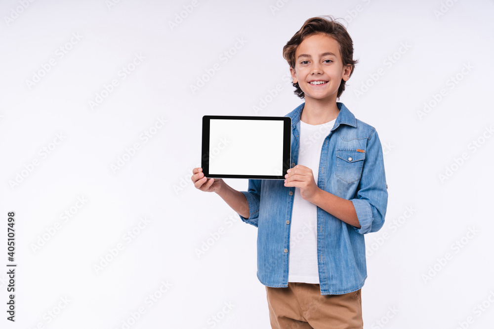 Smiling little boy in casual clothes presenting blank screen of the tablet isolated over white background Smiling little boy in casual clothes presenting blank screen of the tablet isolated over white background