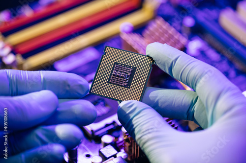 CPU computer processor shallow focus. CPU socket of the computer's motherboard. Concept of computer, motherboard, hardware and technology. Laboratory technician holds a powerful processor in his hands photo