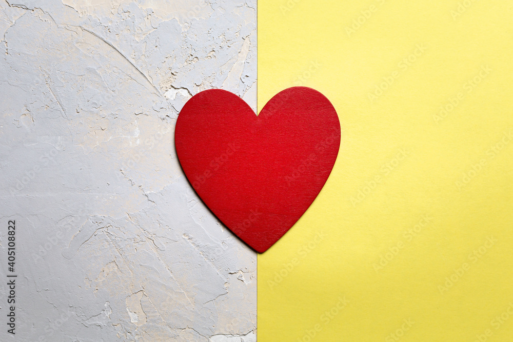 Red painted heart on yellow paper on grey textured background, Saint Valentine day minimalistic card in Pantone 2021 color