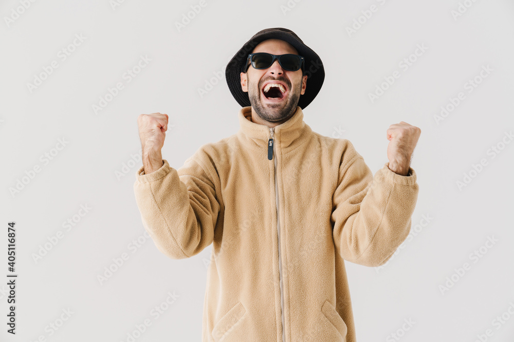Portrait of man wearing beige jacket, cap and sunglasses Portrait of man wearing beige jacket, cap and sunglasses