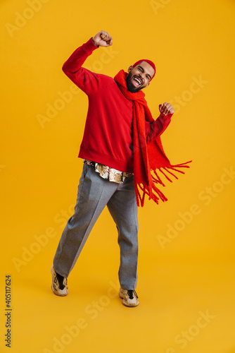 Excited happy african man wearing scarf celebrating