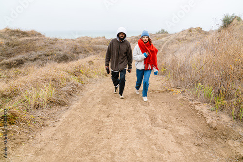 Attractive young multiethnic couple walking at the beachside