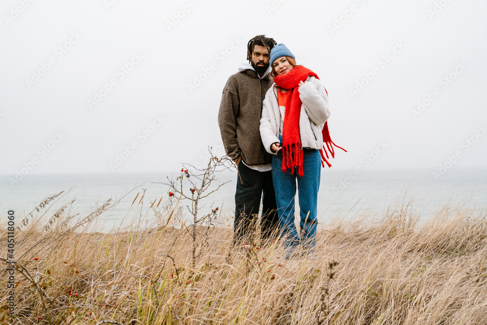 Lovely young multiethnic couple cuddling at the beach Lovely young multiethnic couple cuddling at the beach