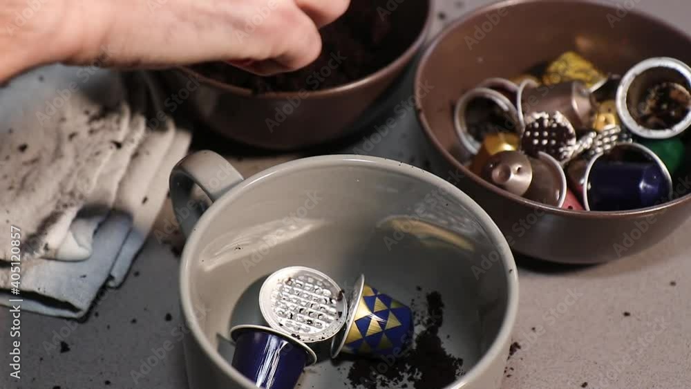 Hombre caucásico vaciando cápsulas de café para llavarlas a reciclar 