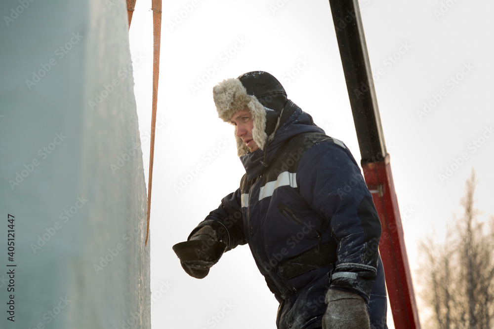 Worker assembler in blue jacket and fur hat at construction site Worker assembler in blue jacket and fur hat at construction site