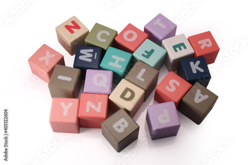 Wooden blocks with letters, white background random letters around