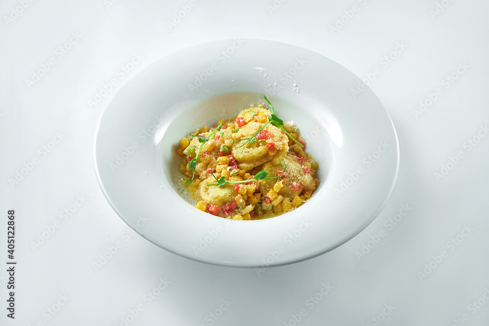 Italian ravioli with various fillings (meat, cheese) with vegetable salsa and parmesan in a white plate on a white plate Italian ravioli with various fillings (meat, cheese) with vegetable salsa and parmesan in a white plate on a white plate
