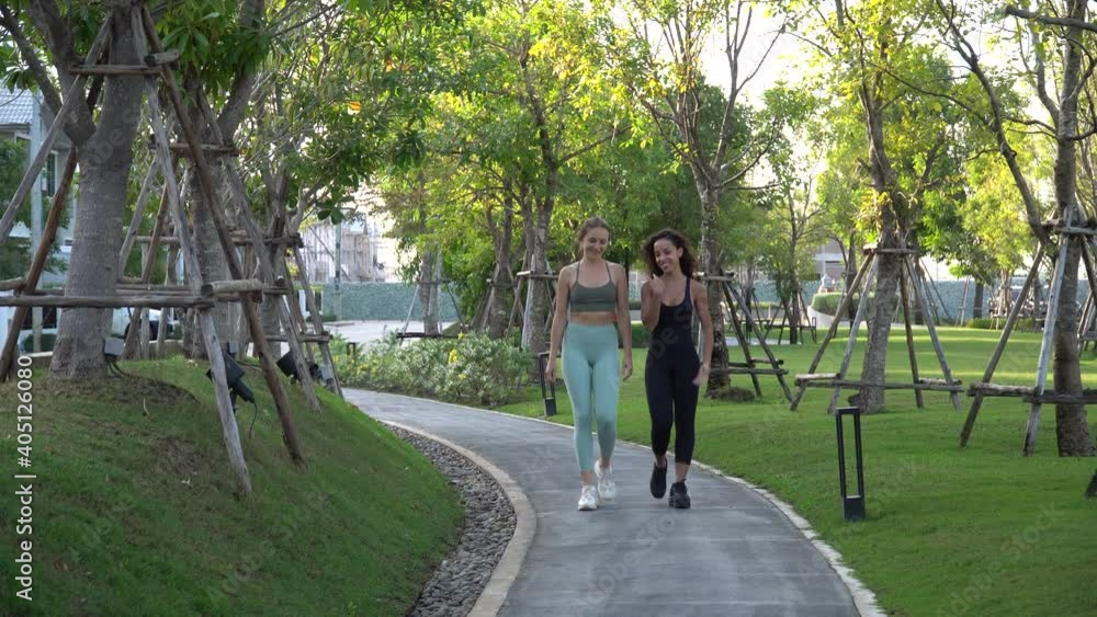 group of two runner woman walking together at park in morning outdoors . fit girl friend training workout . exercise group of two runner woman walking together at park in morning outdoors . fit girl friend training workout . exercise