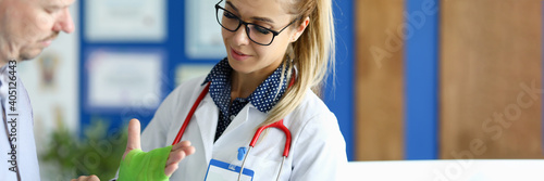Photography Portrait of surgeon making bandaging of hand with elastic bandage