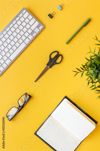 Flat lay office workspace with keyboard and office supplies, top view