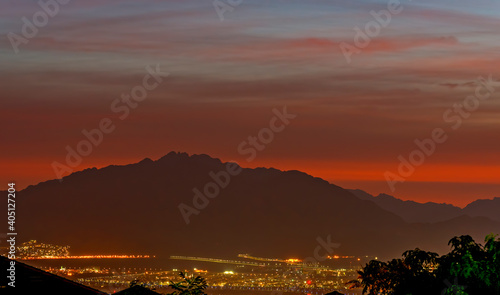 Sunset over mountains and illuminated streets of Aqaba city beneath, Jordan