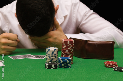 Quadro su tela Devastated gambler man losing a lot of money playing poker in casino, gambling addiction