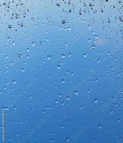 Raindrops on the window against the blue sky.