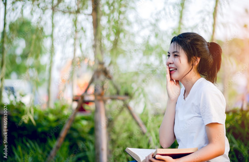 The young woman happily reading the book alone Education and knowledge is a good thing. The young woman happily reading the book alone Education and knowledge is a good thing.