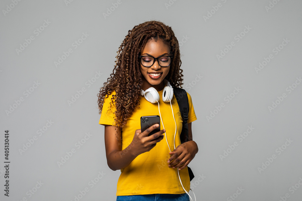 Φωτογραφία Portrait of a happy young african girl student with backpack listening music thr