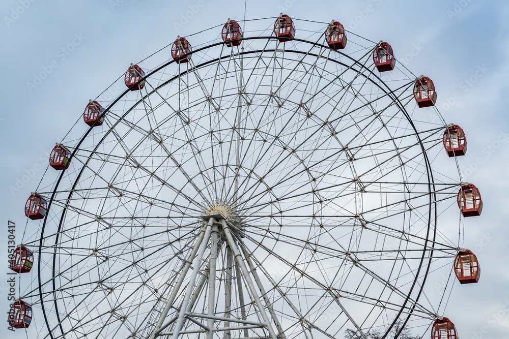 Ferris wheel on blue cloudy sky background Ferris wheel on blue cloudy sky background