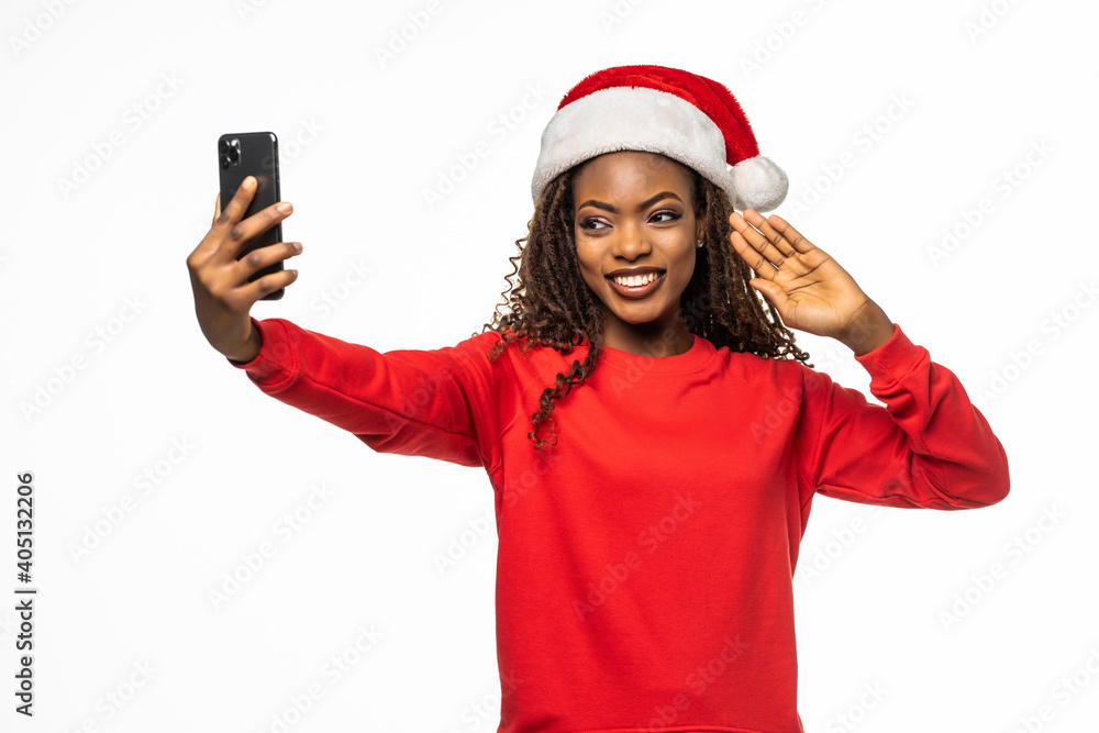 Young african american woman wearing christmas hat and taking a selfie wave with hands on camera over isolated on white background Young african american woman wearing christmas hat and taking a selfie wave with hands on camera over isolated on white background