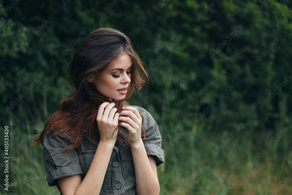 Woman in the forest Green suit eyes closed green trees background summer Woman in the forest Green suit eyes closed green trees background summer