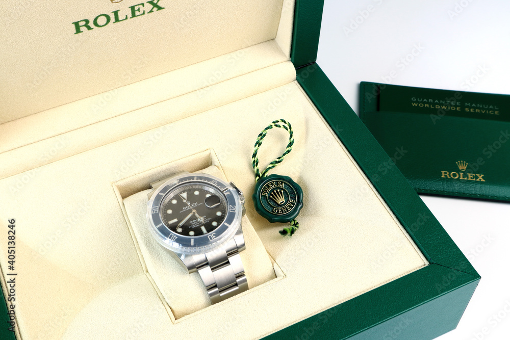 The new full sticker wrapped rubber cover Rolex vintage wrist watch black oyster  perpetual submariner date model , green coin and guarantee manual in the  green box foto de Stock | Adobe Stock