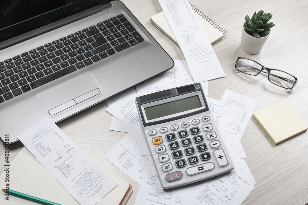 Bills and calculator with checks for goods and services.. calculator to calculate bills at the table in office. Calculation of costs. Bills and calculator with checks for goods and services.. calculator to calculate bills at the table in office. Calculation of costs.
