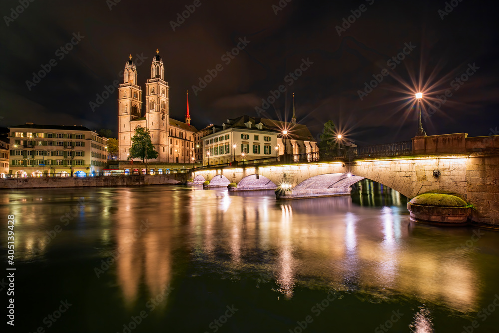 Fototapeta premium Picturesque night view of Grossmuenster church, town hall and Minster Bridge across Limmat river in Zurich, Switzerland