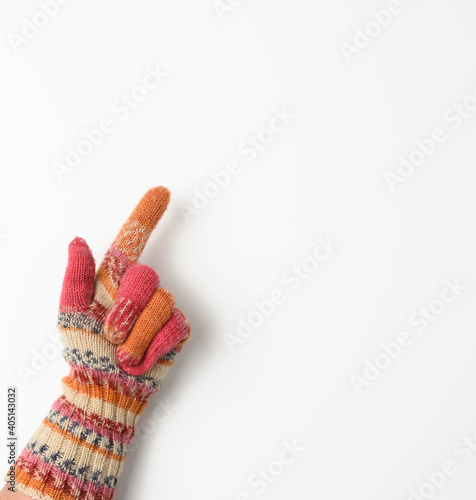 female hand in a knitted mitten on a white background