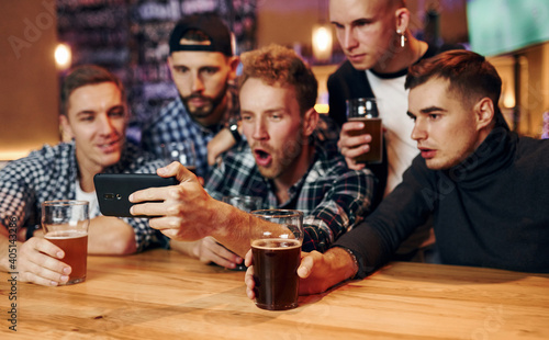 Group of people together indoors in the pub have fun at weekend time