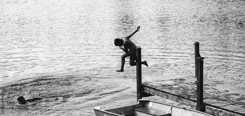 Full Length Of Shirtless Boy Jumping In Lake Stock Photo | Adobe Stock