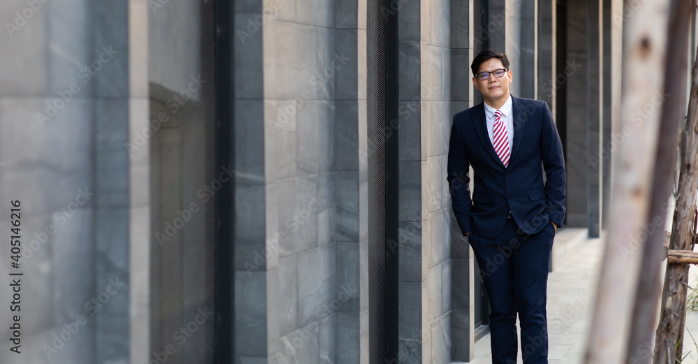 Portrait of a cheerful Asian man using smart phone at modern office. Peoples addicted to technology Portrait of a cheerful Asian man using smart phone at modern office. Peoples addicted to technology