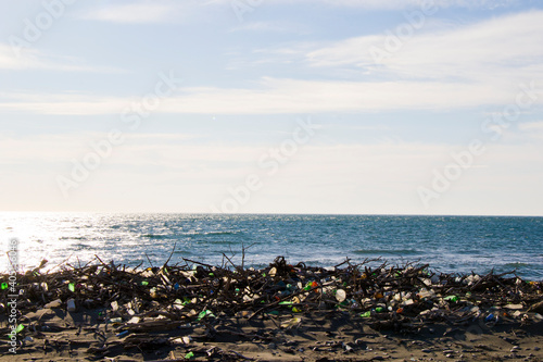 Garbage on the sandy beach, plastic and metal pollution, global warming