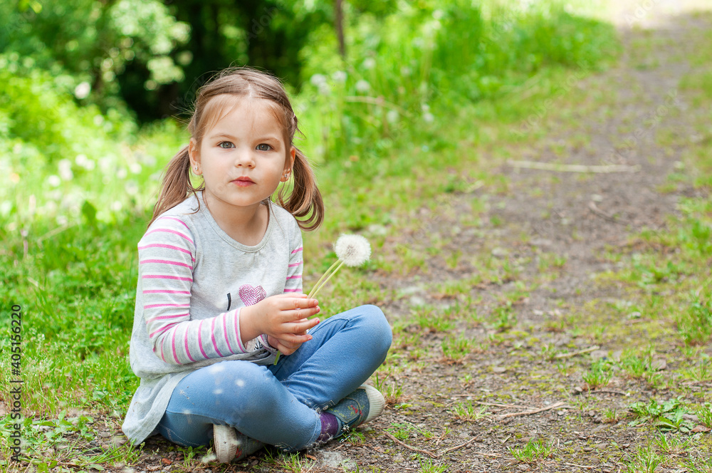 Joyful and happy girl play with of dandelions in the park. Happy childhood concept. Joyful and happy girl play with of dandelions in the park. Happy childhood concept.