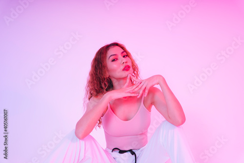 Bilde på lerret Portrait of young asian woman in pink cloth and white sporty pant in studio light background