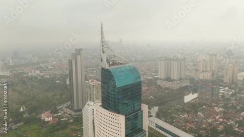 Close up aerial dolly shot of the top of Wisma 46 skyscraper in Jakarta, Indonesia on a cloudy day photo